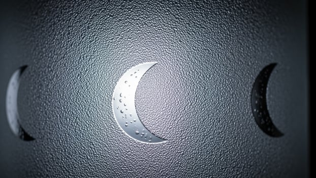 A crescent moon is shown on a wall photo