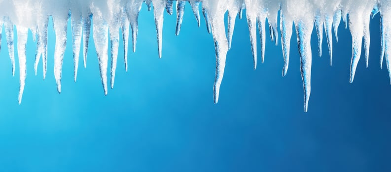 Icy winter scene with blue backdrop featuring melting icicles and copy space photo