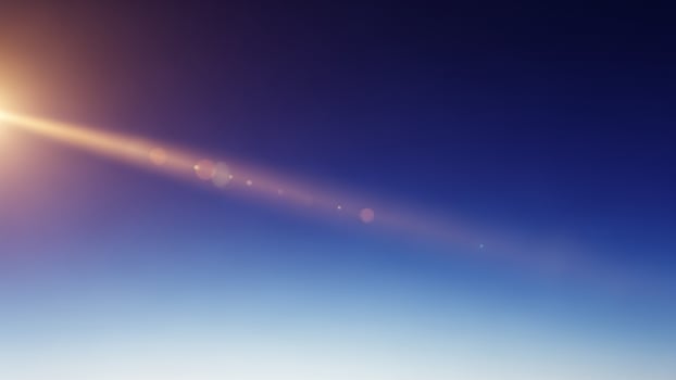 Sun shining over the ocean with a plane in the background photo