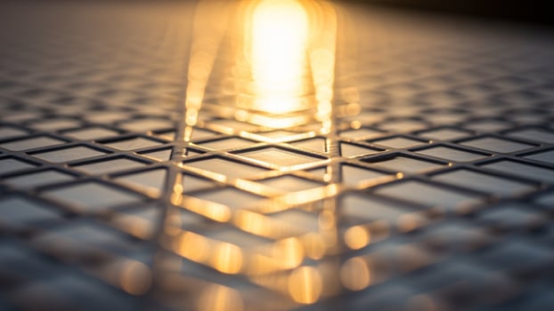 A close up of a metal grid with a light shining through it photo