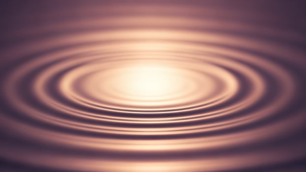 A circular rippling pattern of water on a dark background photo