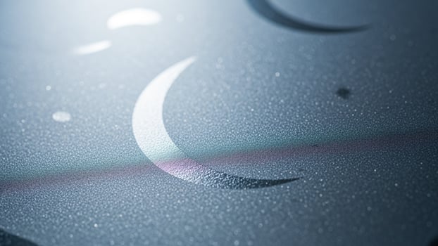A crescent moon and stars are shown on a glass surface photo