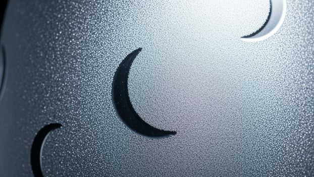 A close up of a metal object with a moon on it photo
