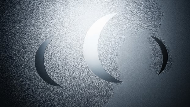 A silver metal wall with a crescent moon on it photo