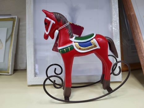 A red statue of a rocking horse on a white background. photo
