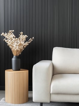 Contemporary interior with neutral sofa side table and floral arrangement on black wall photo