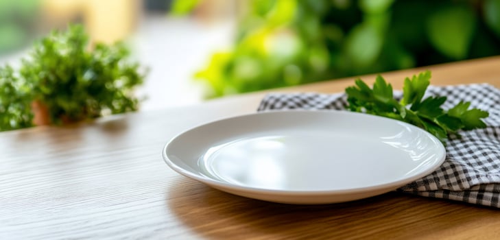 Empty plate with checkered napkin and herbs on wood table for food preparation photo