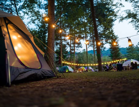 Camping adventure with illuminated tents and string lights at dusk photo