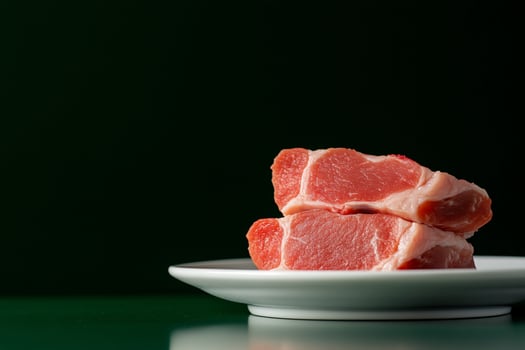 Fresh raw pork loin chops on white plate for cooking photo