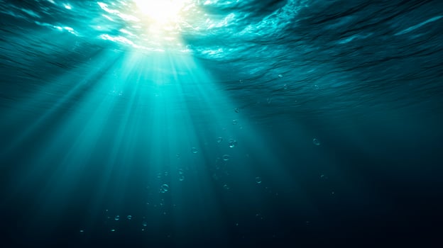 Underwater sunbeams piercing turquoise ocean water with bubbles image photo