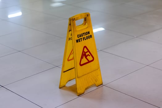 A yellow caution wet floor sign in the public area. Wet floor warning and caution sign. photo