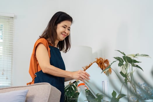 Housekeeping service with a woman organizing books and plants. photo