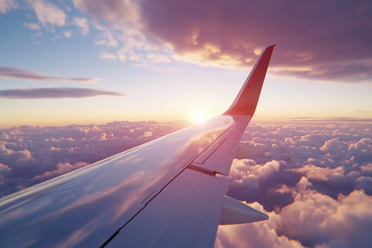 Airplane wing over clouds at sunset aerial travel and flight scenery photo