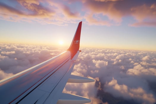 Airplane wing over clouds at sunset aviation travel and flight photo