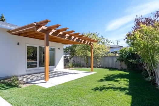 Backyard patio with wooden pergola on sunny day photo