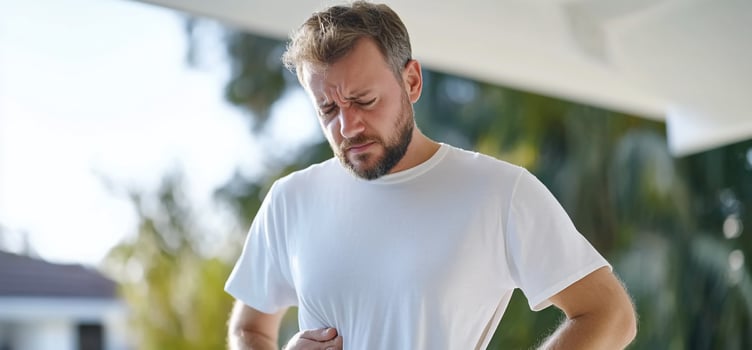 Man experiencing abdominal pain or discomfort health and wellness concept photo
