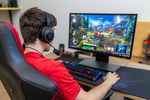Person playing game on computer with headset and keyboard photo