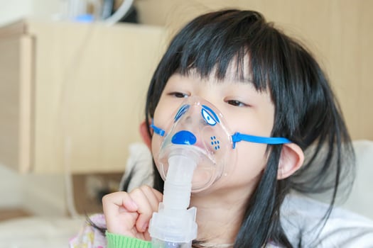 A young girl with an oxygen mask on her face photo