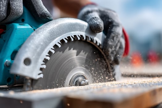 A person is using a circular saw to cut wood photo