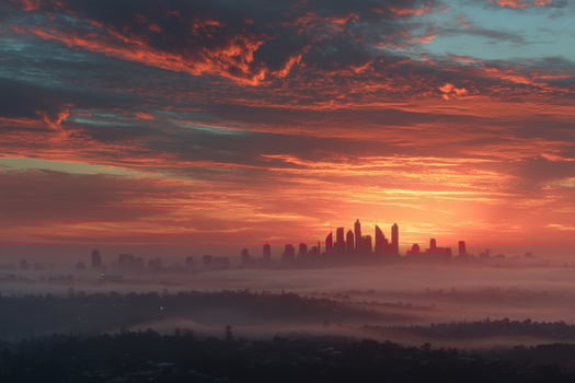 A city skyline is seen in the distance with a foggy sky photo
