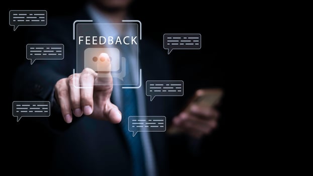Businessman touching virtual feedback icon on digital interface with chat bubbles, representing customer review, communication, and online service evaluation concept for business and marketing use. photo