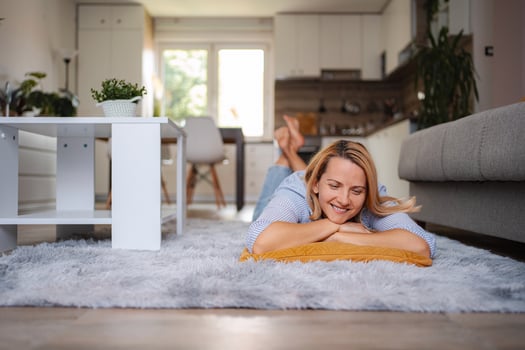 Woman relaxing on carpet in living room enjoying weekend photo