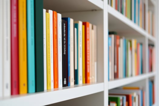 Colorful books arranged on white bookshelf education and literature concept photo
