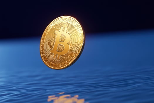 Gold coin symbolizing digital currency above water photo