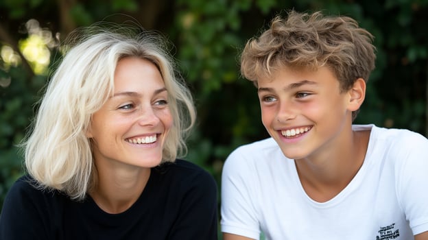 Candid portrait of smiling woman and teenage boy with blurred green background photo