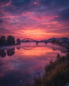 Peaceful sunrise over a silent city river with warm morning glow and delicate mist rising from the still waters in a tranquil urban setting photo
