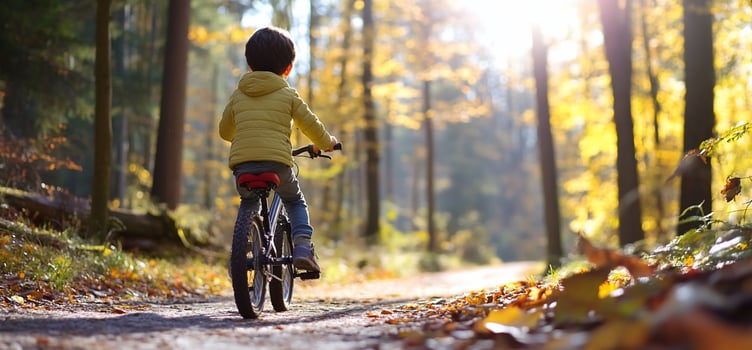 Child biking through autumn forest scenic outdoor activity photo