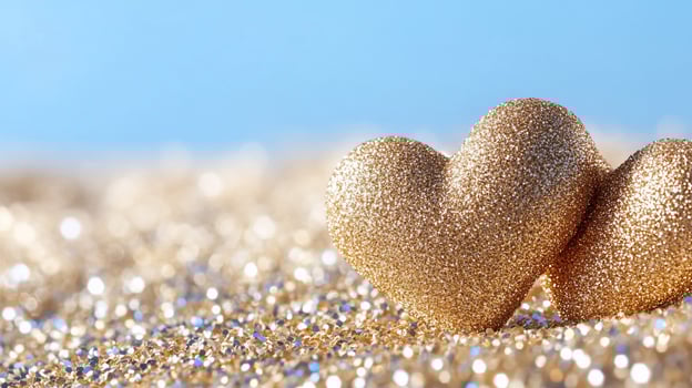 Golden heart pair on glitter surface sparkling love and affection theme photo