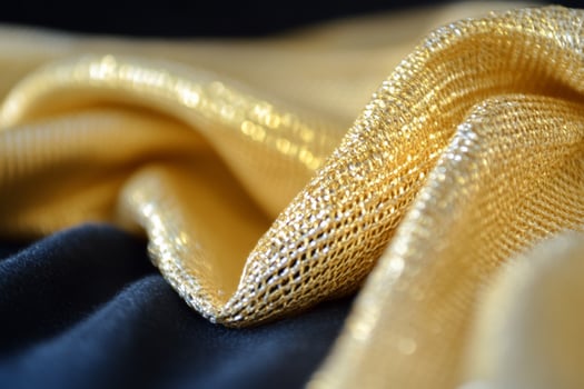 Golden mesh fabric texture on blue velvet background photo