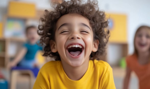 Happy child laughing with friends in bright classroom portrait photo