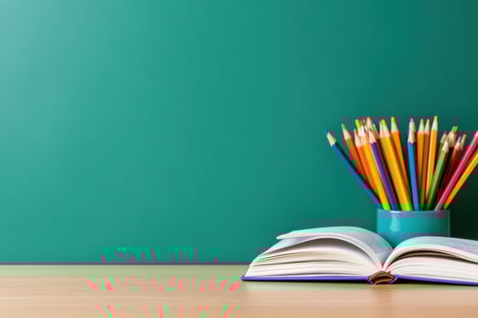 Open book with colored pencils on desk for creative education and learning photo