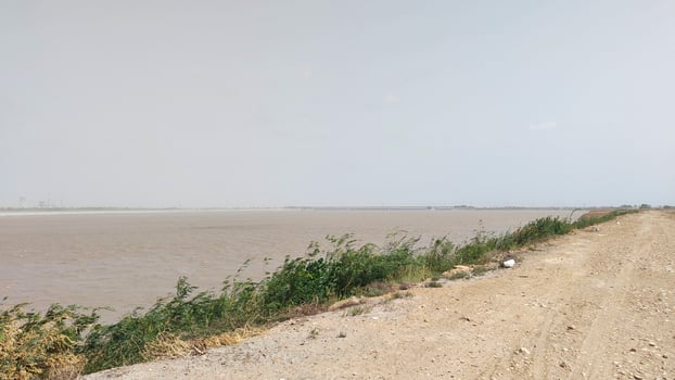 Muddy River Bank and Dirt Road on a Cloudy Day photo