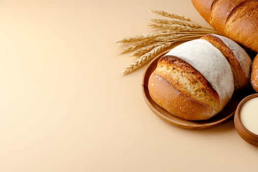 Artisan baked bread assortment with wheat stalks on neutral background photo