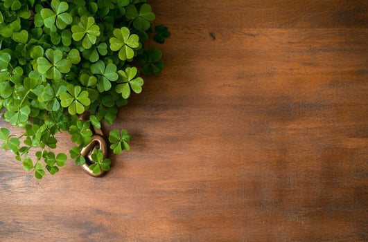 Green clover and golden ornament on wood background with copy space photo