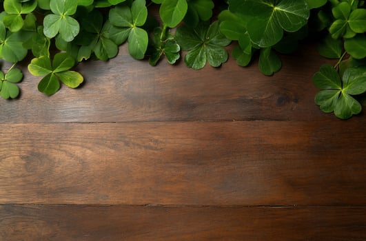 Green shamrock leaves bordering dark wood background photo