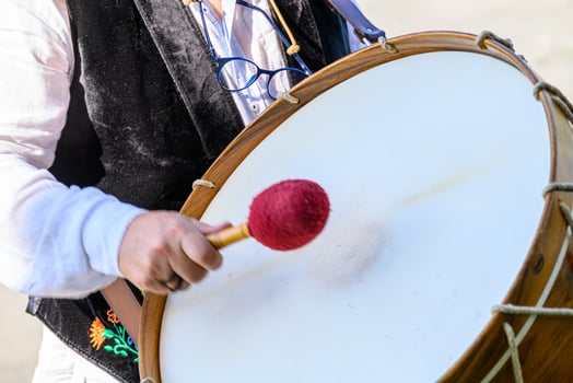 Close up of a drummer hitting a large drum with a red mallet live music concept photo