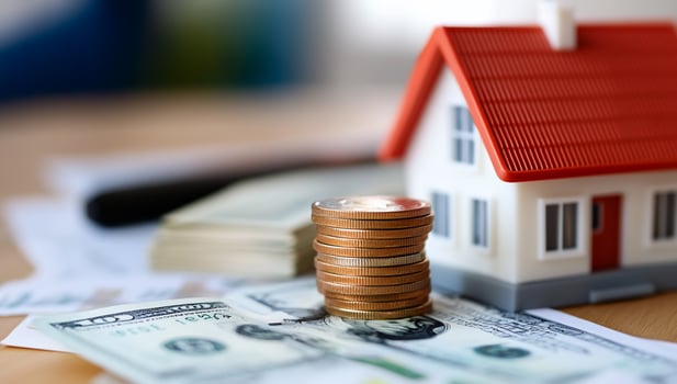 Miniature house with money and coins representing home finance investment photo