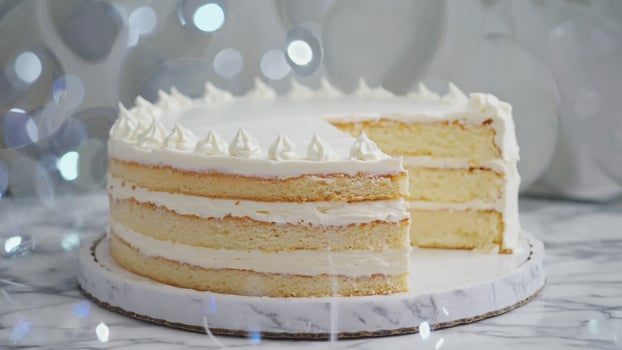 Layer Cake with Creamy White Frosting on Marble Serving Board photo
