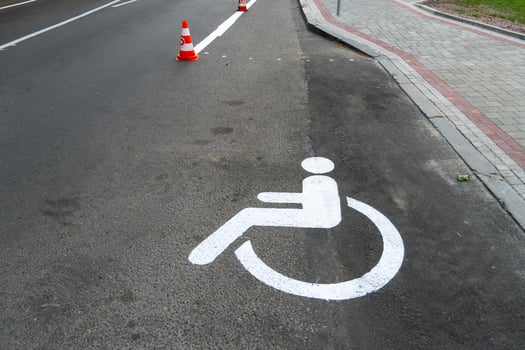 A white handicap symbol painted on the side of a road photo