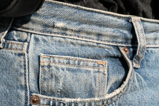 A person holding a cell phone in their pocket photo