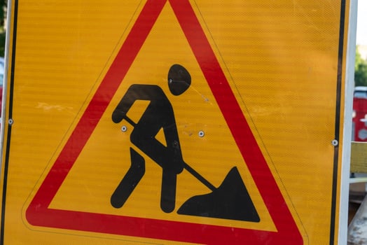 A yellow sign with a man in a shovel photo