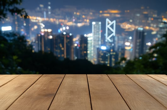 Wooden table top with blurred cityscape background at night for product display photo