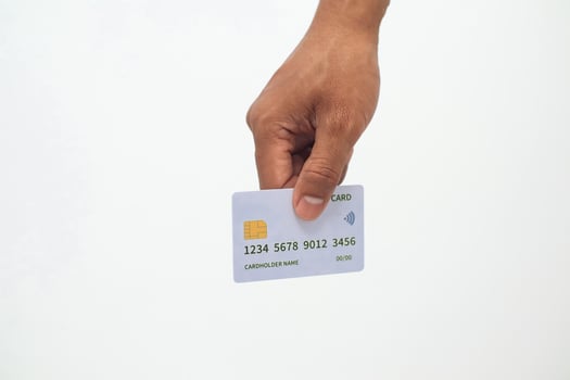 Hand holding a credit card against white background, paying with card concept photo