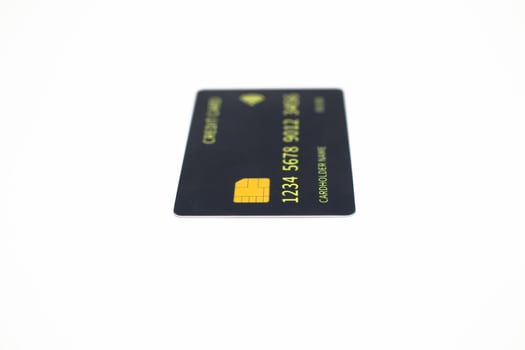 Close-up studio shot of a black credit card with chip against a white background photo