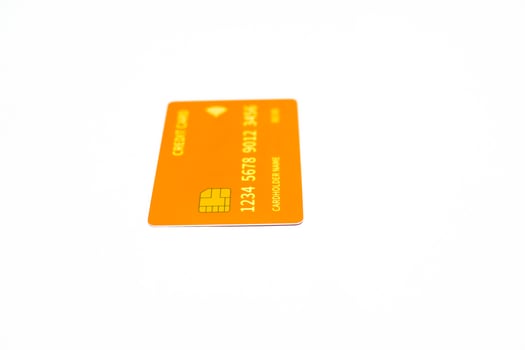 Macro shot of an orange credit card with chip on a bright white background, representing financial technology and payment solutions photo