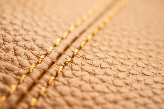 Closeup of a brown leather bag with gold stitching photo